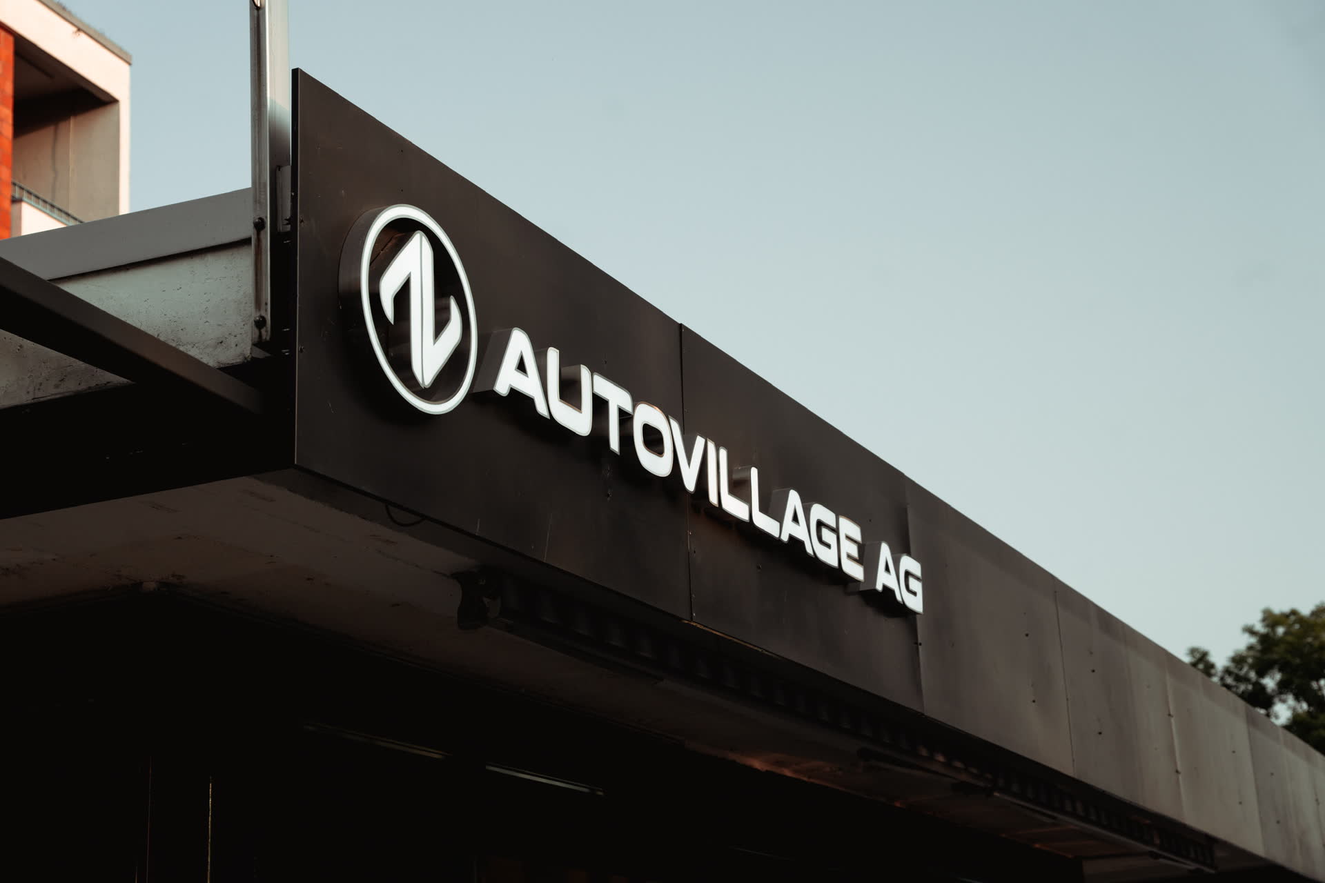 Leuchtschrift AUTOVILLAGE AG an der Fassade